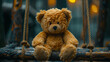 teddy bear sitting on a swing. concept of loneliness