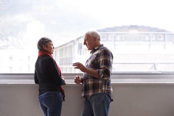 Canvas Print - Window, mature couple and talking for communication, conversation and discussion of retirement holiday. Smile, elderly people and marriage for bonding, commitment and planning for romantic vacation