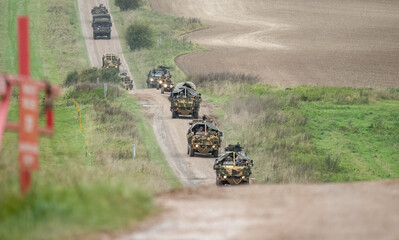 a convoy of British army Supacat Jackal 4x4 rapid assault, fire support and reconnaissance vehicle with camouflage, in action on a military exercise, Wilts UK