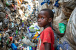 Togolese little boy looks ahead at the garbage dump. Togo children suffer from poverty due to the bad economy