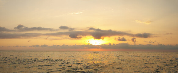 Wall Mural - golden sunrise sky with sun and cloud under sea, panoramic sunset outdoors background