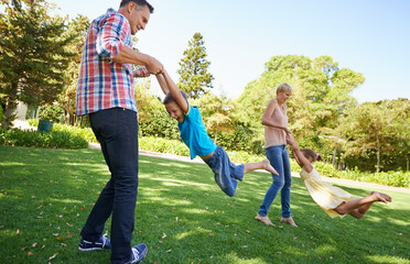 Canvas Print - Parents, children and spinning fun in garden for bonding game together on park field for summer, recreation or connection. Mother, father and siblings with laugh on backyard grass, family or carefree