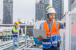 © eakgrungenerd - Man engineer holding laptop working at rooftop building construction. Male technician worker working checking hvac of office building. Engineering installing large air conditioning system.