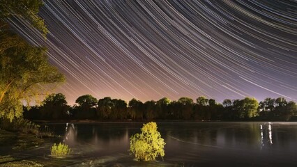 Wall Mural - Night Sky Turns Into Morning. Amazing Starry Effects. Star Trails On Night Sky Background. 4k Timelapse Night Sky Above River. Star Lines Move In Sky. From Dusk To Dawn. Dawn Is Coming. Time Lapse