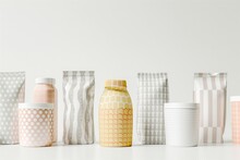Variety Of Patterned Ceramic Vases Or Paper Boxes In Neutral Tones Displayed Against A Clean, White Backdrop