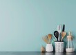 Modern kitchen utensils on gray table against light blue wall background, space for text stock