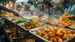 Variety of Dishes Ready at a Busy Food Stall. Street food stall offers a variety of dishes, with a vendor serving to eager customers.
