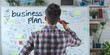 © paffy - Young entrepreneur brainstorming business plan on whiteboard - concept of startup strategy and creative thinking