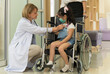 © boonsom - Caucasian female doctor hand using medical stethoscope for checking heartbeat rate of little girl patient in a wheelchair in hospital . Healthcare and insurance concept.