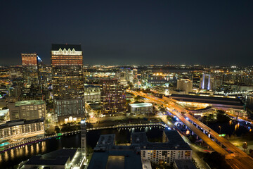 Poster - View from above of brightly illuminated high skyscraper buildings and moving traffic in downtown district of Tampa city in Florida, USA. American megapolis with business financial district at night