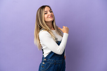 Wall Mural - Young woman over isolated purple background proud and self-satisfied