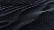 A detailed view of a black sand dune, showcasing its texture and patterns.