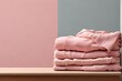 Stack of freshly laundered, folded sweaters on table with copy space. Close up of warm cozy comfortable monochrome clothes for autumn winter season.