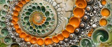 Close-up Photo Of An Art Piece, Showcasing Orange And Green Circles Circles Are Positioned At Bottom And Top Of Image