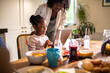 © Marko Geber - Mother and daughter using tablet during breakfast in the kitchen