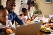 © Marko Geber - Young family having breakfast in the morning and using the laptop