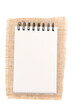 Notepad on jute, burlap. Notepad on white background - top view. 