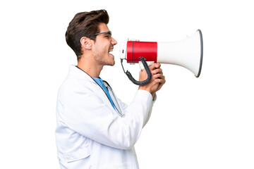 Wall Mural - Young doctor man over isolated background shouting through a megaphone