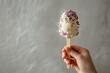 milk ice cream on a stick covered with eatable flowers