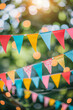 Multicoloured triangular flags on a string, garland hanging outdoors, birthday party celebration