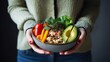 An inviting bowl of colorful vegetables and grains presented by a woman, suggesting a healthy and delightful meal option