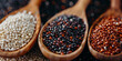 Red, black and white quinoa grains in a wooden spoon. Healthy food background. Seeds of white, red and black quinoa - Chenopodium quinoa