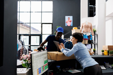 Sticker - African american courier discussing shipping details with employee, checking online order in on tablet computer. Store worker standing at counter desk, preparing packages for delivery in boutique