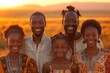 A happy African family of five posing together for a photo in the desert at sunset.
