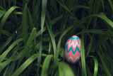 Fototapeta  - Pink decorated Easter Egg hidden tall grass found during Easter Egg hunt search.