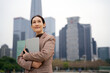 © 昊 周 - Confident Businesswoman in Urban Setting with Tablet