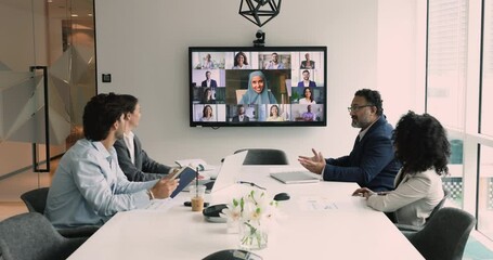 Poster - Group of businesspeople met in board room take part in negotiations, listen speech of Sudanese businesslady in hijab lead tele-meeting with partners, share strategy engaged in on-line virtual meeting