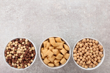 Poster - Various corn flakes in bowls on grey background