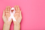Fototapeta Koty - Breast cancer concept. Female hands holding pink ribbon