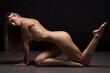 © Anton Belovodchenko - Athletic natural woman body on dark background. Nude woman Yoga.