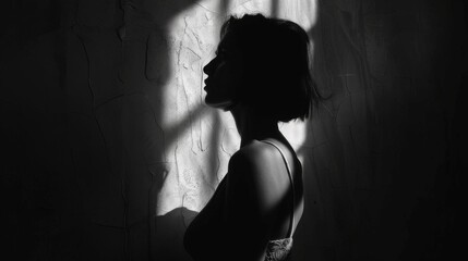  Silhouette of a young woman in a dark room with shadows
