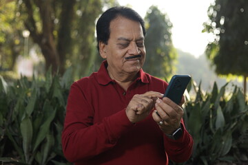 Woman chatting on smart phone Standing in a lush green park. Shallow Depth. Typing and working from anywhere. Doing business independently. using advanced wireless technology.