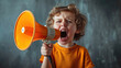 small child boy, angry, screaming into a bullhorn on a gray background, holding an orange loudspeaker in his hands, open big mouth