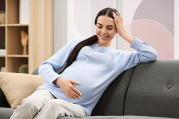 Poster - Happy pregnant woman on sofa at home