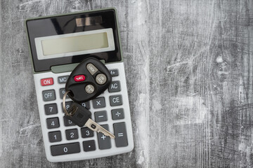 Sticker - A black calculator with car keys on weathered wood desk