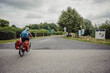 Frau radelt während einer Radreise durch das Münsterland auf dem Radschnellweg Radbahn zwischen Coesfeld und Rheine und überquert dabei eine Straße, Kreis Coesfeld, Baumberge