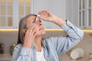 Poster - Woman applying medical eye drops at home