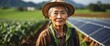 © Arceli - A elderly asian farmer woman on farm fields with solar panels on the side for green renewable energy banner copyspace from Generative AI