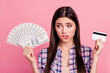 Close-up portrait of her she nice-looking attractive cute charming lovely winsome puzzled confused straight-haired lady holding in hands cash card shopaholic isolated over pink background
