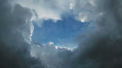 Wall Mural - Storm clouds and hole with blue sky