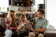 © BGStock72 - Family bonding time with playful french bulldog pup in cozy living room
