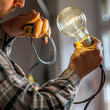 Close-up of an electrician screwing in a light bulb.