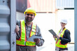© Washburn - Warehouse engineer inspects the inside of a container with a customer at an industrial container yard.