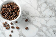 Cup with coffee beans and a small pile of ground coffee on the table, minimalist simple 3d illustration isolated on white marble background. Flat lay top view mockup with copy text