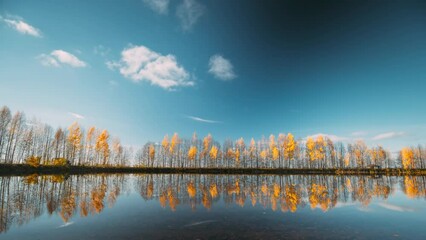Wall Mural - Autumn Forest woods lake coast. Landscape Woodland Slider Time Lapse, Time-lapse. reflection on water surface wide angel, tranquil motion. Autumn River Landscape At Sunset.
