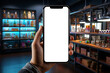 © tynza - Mobile Shopping: A person holding a mobile device with white screen on blurred store interior background.